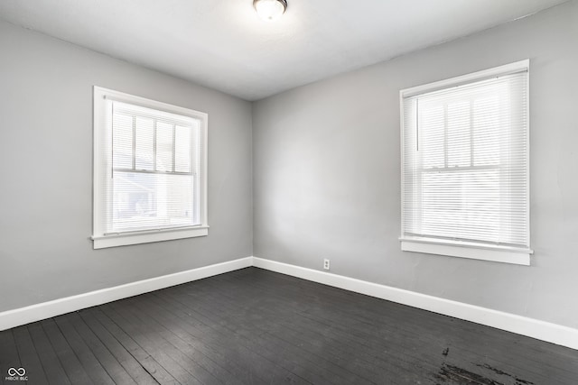 unfurnished room with dark wood-style floors and baseboards