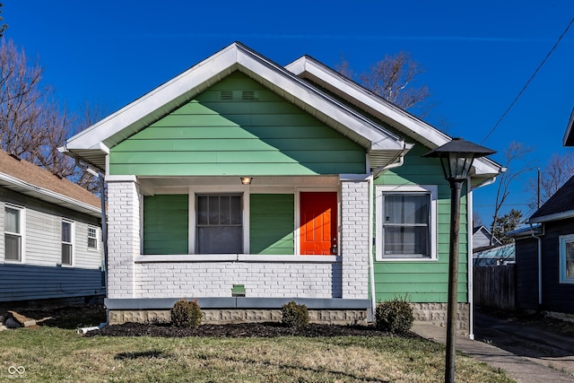 bungalow-style house featuring a porch and brick siding