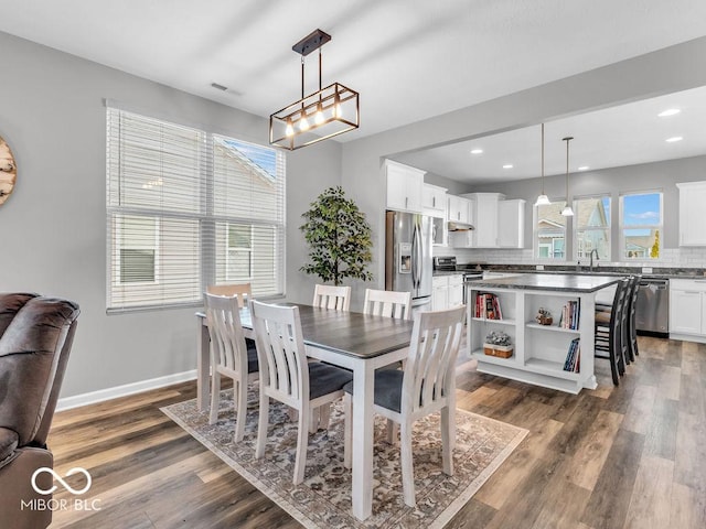 dining area with dark wood-style floors, plenty of natural light, and baseboards