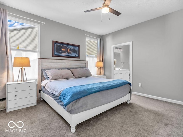 bedroom with light carpet, ensuite bath, multiple windows, and baseboards