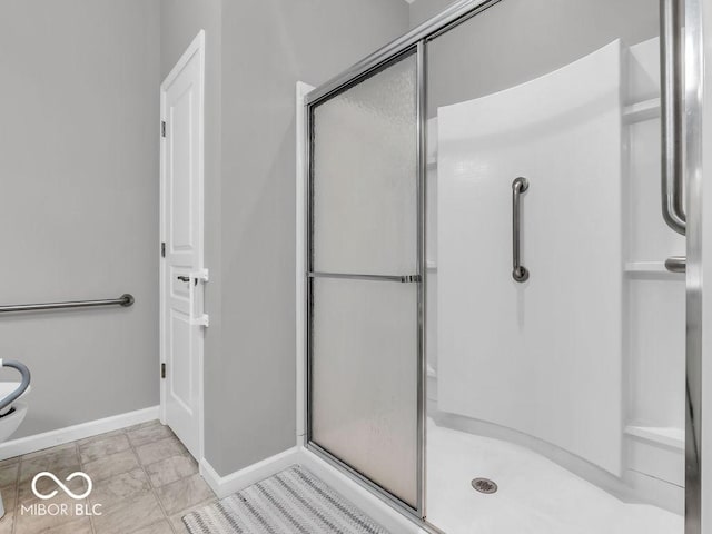 bathroom with a stall shower and baseboards