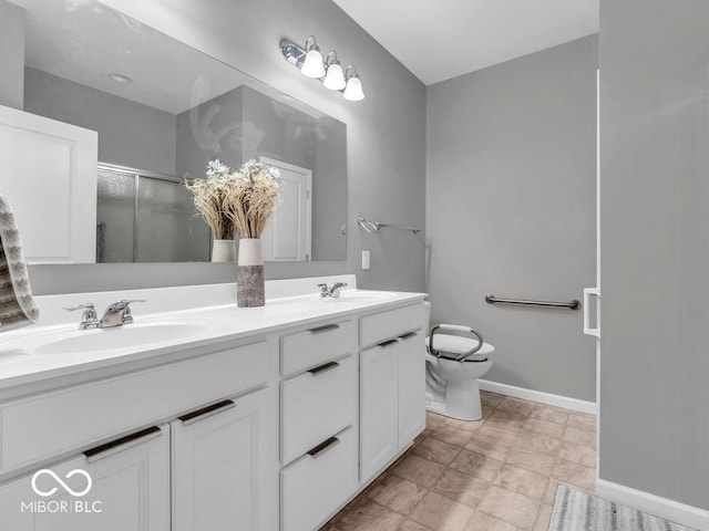 bathroom featuring toilet, a sink, baseboards, double vanity, and an enclosed shower