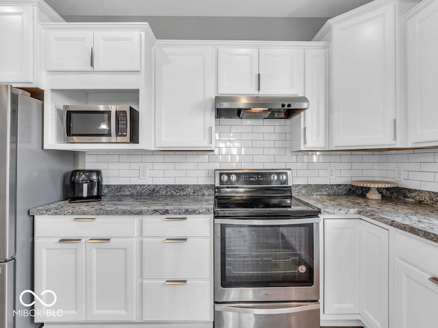 kitchen featuring appliances with stainless steel finishes, white cabinets, under cabinet range hood, and decorative backsplash