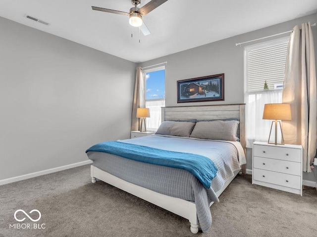 bedroom featuring a ceiling fan, visible vents, light carpet, and baseboards