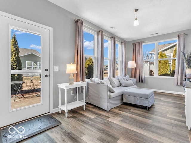 sitting room featuring visible vents, baseboards, and wood finished floors