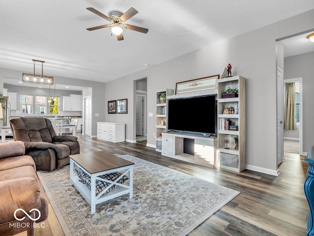 living room with baseboards, a ceiling fan, and wood finished floors