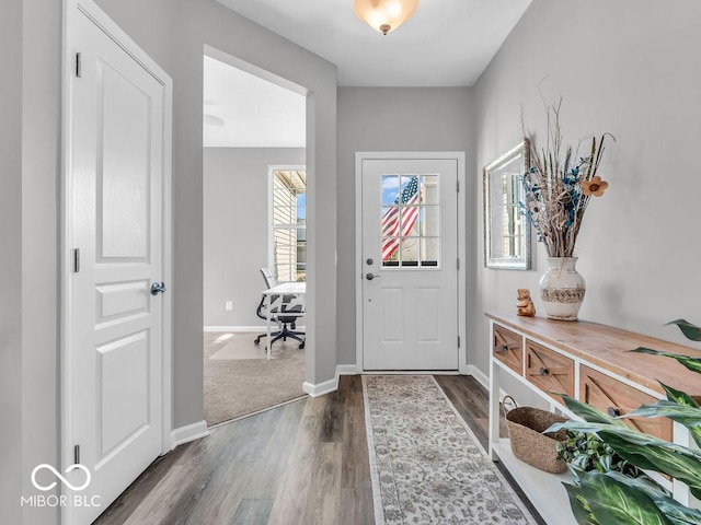 foyer with baseboards and dark wood-style flooring