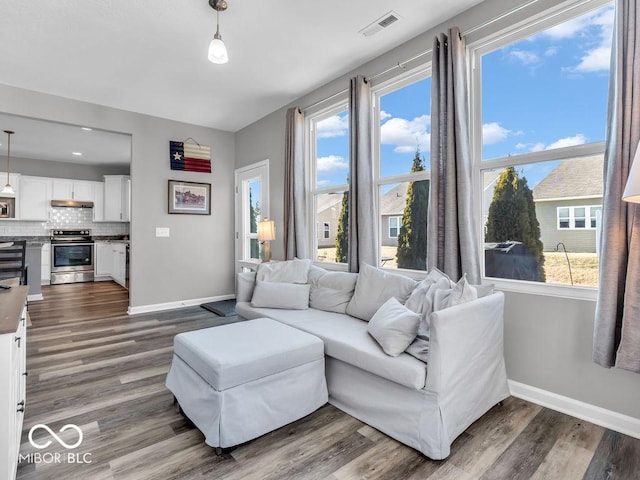 living room with dark wood-style floors, baseboards, and visible vents