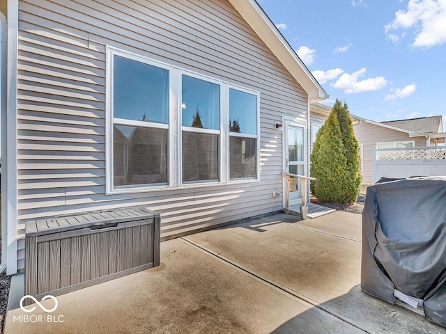 view of property exterior featuring a patio and fence