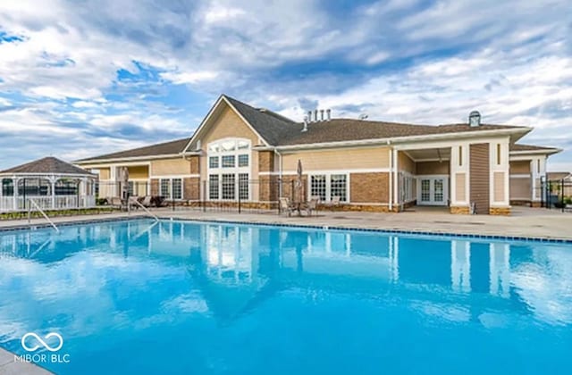 pool featuring french doors and fence