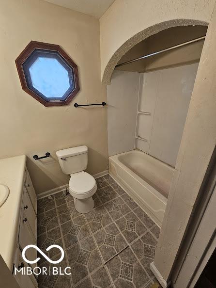 full bathroom featuring toilet, bathtub / shower combination, baseboards, tile patterned flooring, and vanity