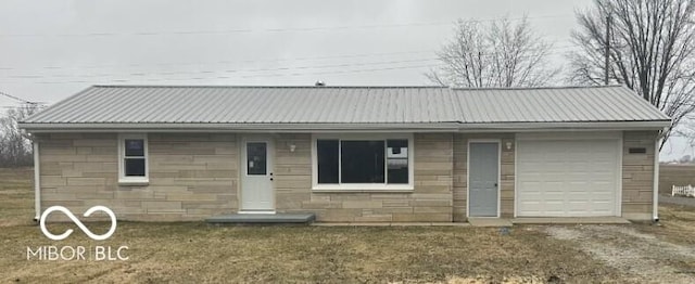 ranch-style home with stone siding, driveway, metal roof, and an attached garage