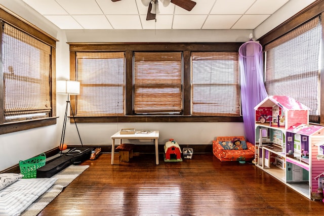 playroom featuring a paneled ceiling, hardwood / wood-style flooring, and ceiling fan