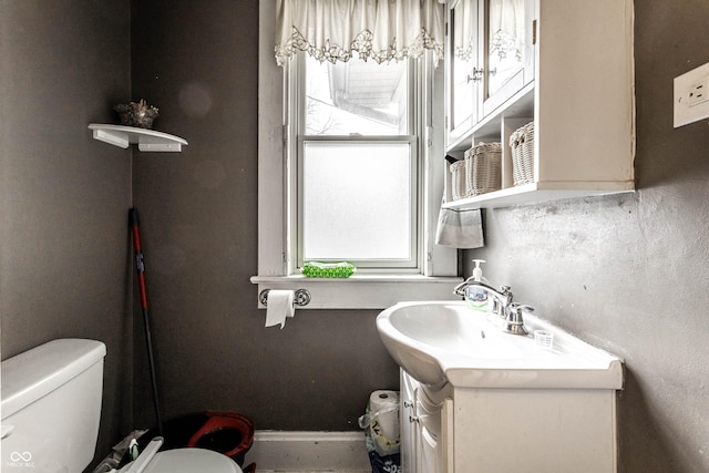 bathroom with vanity, toilet, and baseboards