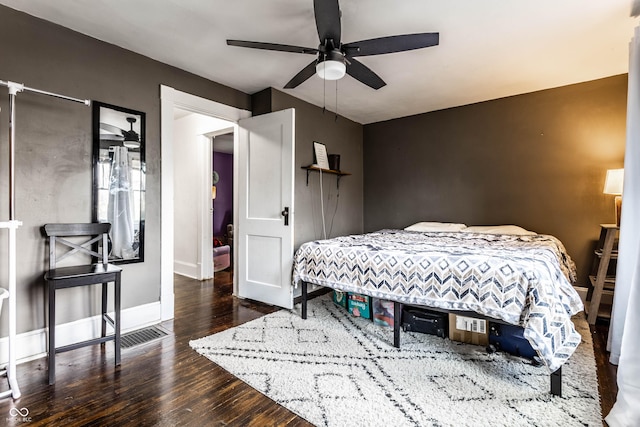 bedroom featuring ceiling fan, baseboards, and wood finished floors