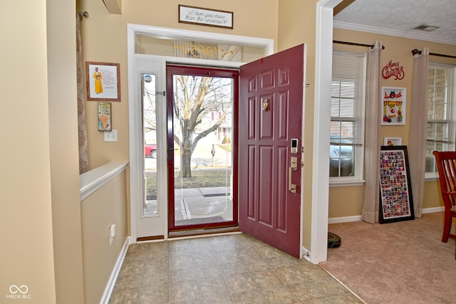 entrance foyer with light carpet, baseboards, visible vents, a textured ceiling, and crown molding