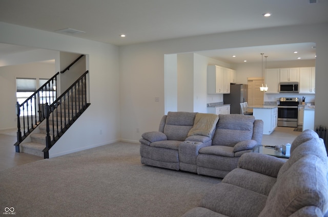 living area featuring stairs, baseboards, light carpet, and recessed lighting