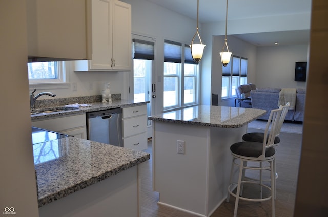 kitchen with dishwasher, open floor plan, hanging light fixtures, white cabinetry, and a sink