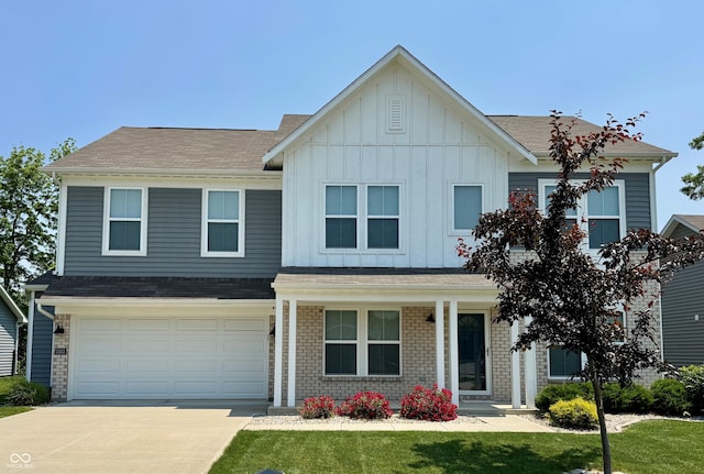 5303 Rum Cherry Way, Indianapolis, IN 46237 - view of front of home with driveway, board and batten siding, a garage, covered porch, and a front yard