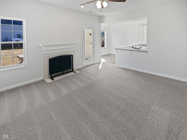 unfurnished living room with baseboards, ceiling fan, carpet flooring, a fireplace, and recessed lighting