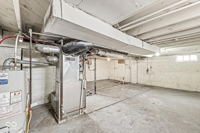 basement with water heater, visible vents, and heating unit