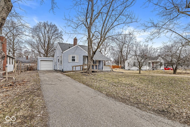 view of front of house featuring a garage, a shingled roof, driveway, a wooden deck, and a chimney