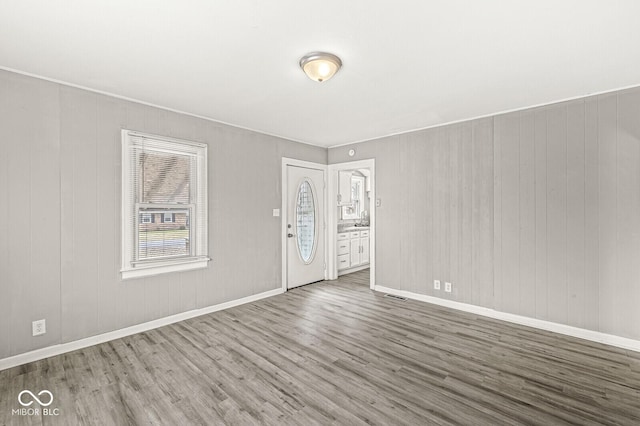 spare room featuring visible vents, baseboards, and wood finished floors