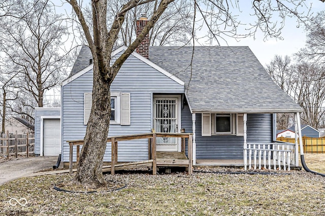 view of front of home featuring roof with shingles, fence, a chimney, and an outdoor structure