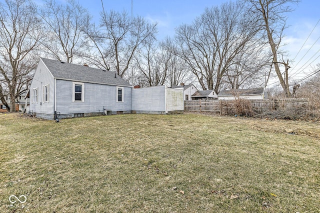 exterior space with roof with shingles, a chimney, fence, and a yard