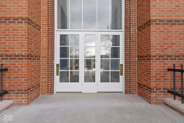 property entrance featuring french doors and brick siding