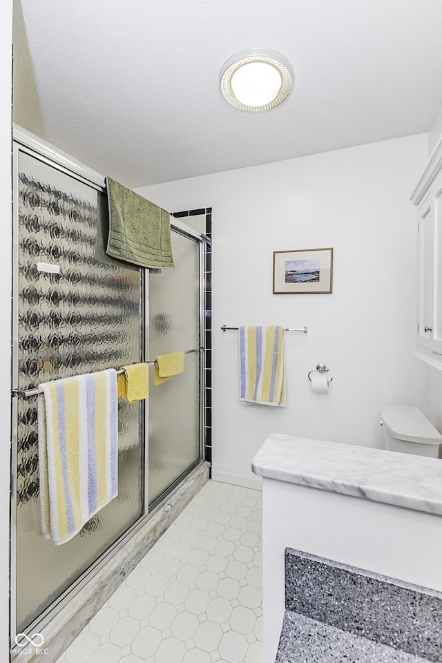 full bath featuring a shower stall and toilet