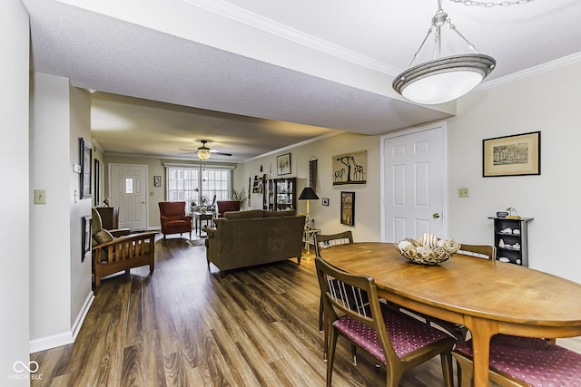 dining space with ornamental molding, a ceiling fan, baseboards, and wood finished floors