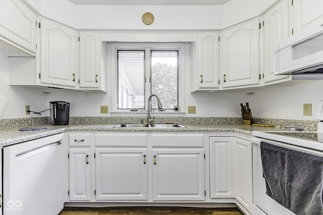 kitchen with white appliances, white cabinetry, and a sink