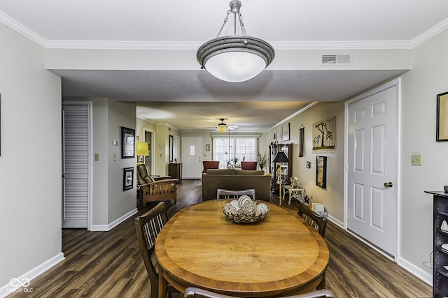 dining room with dark wood-style flooring, visible vents, and crown molding