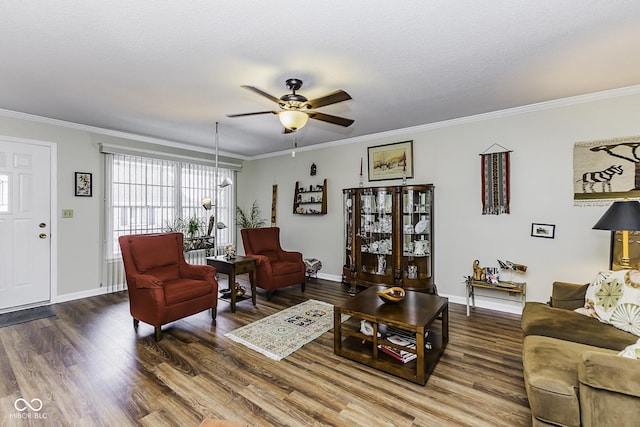 living area featuring crown molding, baseboards, and wood finished floors