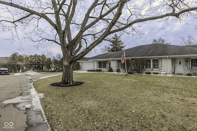 ranch-style home featuring a garage, concrete driveway, brick siding, and a front lawn