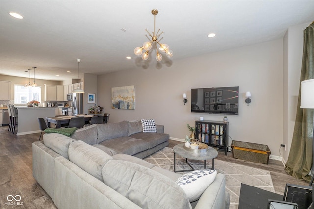 living area featuring baseboards, an inviting chandelier, wood finished floors, and recessed lighting