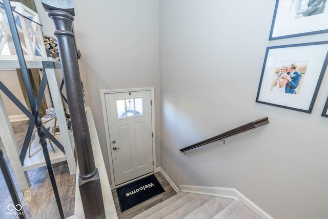 foyer entrance featuring stairs and baseboards