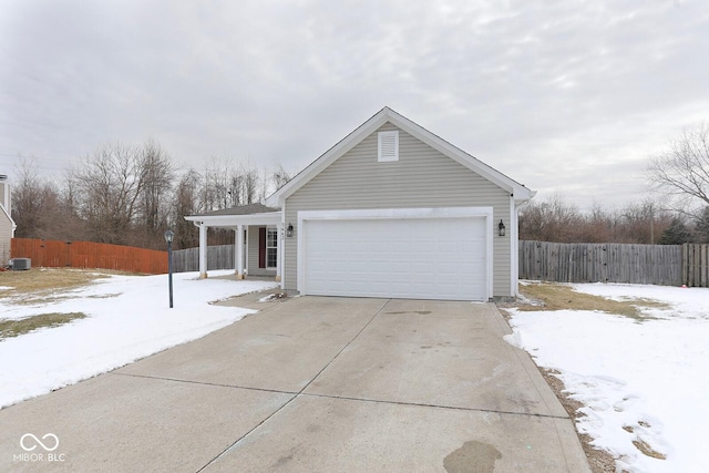 view of front of property featuring concrete driveway, fence, and an attached garage