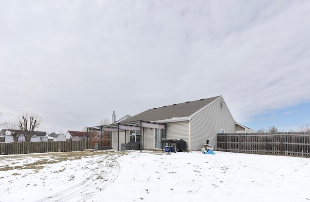 snow covered property with a fenced backyard