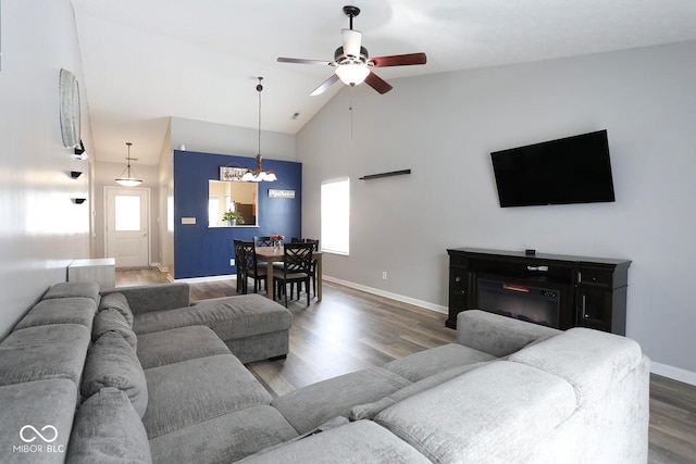 living room featuring a ceiling fan, a healthy amount of sunlight, baseboards, and wood finished floors