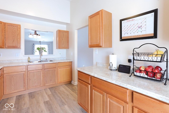 kitchen with light brown cabinets, a sink, and light wood-style floors