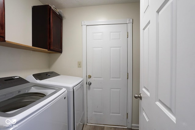 laundry room featuring a textured ceiling, cabinet space, and washer and dryer