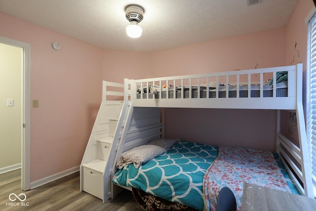 bedroom with baseboards and wood finished floors