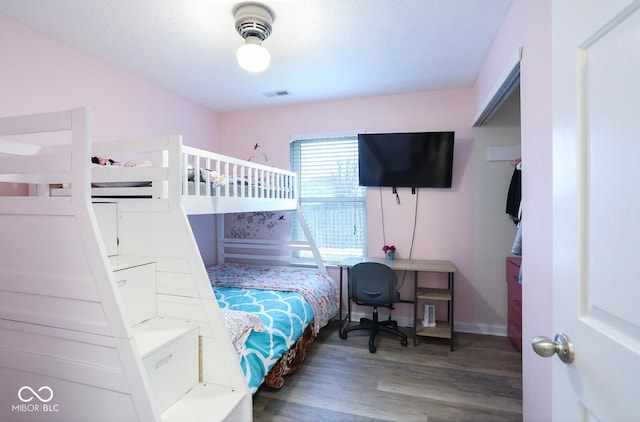 bedroom featuring visible vents, baseboards, and wood finished floors