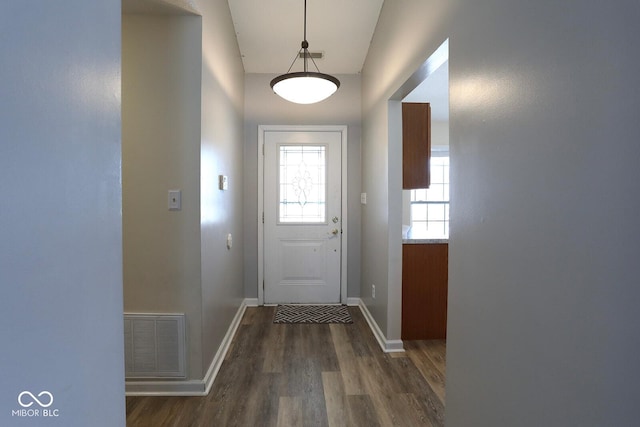 entryway with baseboards, visible vents, and dark wood-style flooring