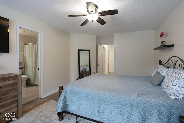 bedroom featuring a textured ceiling, wood finished floors, a ceiling fan, and connected bathroom