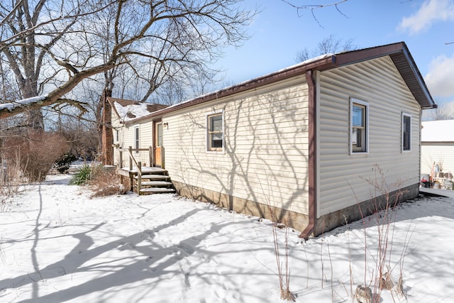 view of snowy exterior featuring a garage and crawl space