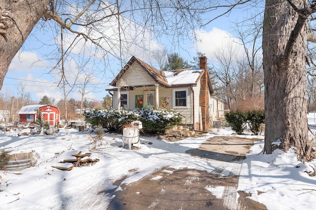 view of front of home featuring a shed and a chimney