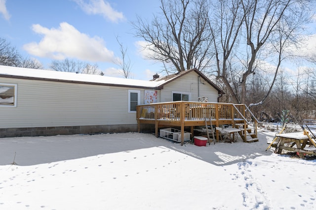 snow covered rear of property featuring a deck and crawl space